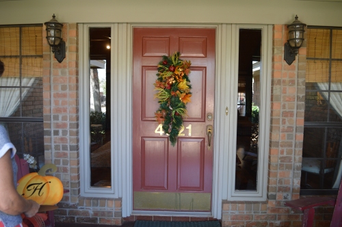 Faux pine teardrop and fall foliage teardrop are wired together fall doorway decor.